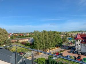 Widok z tarasu Wczasowa 8 na ulicę dojazdową i parking w Sarbinowie
