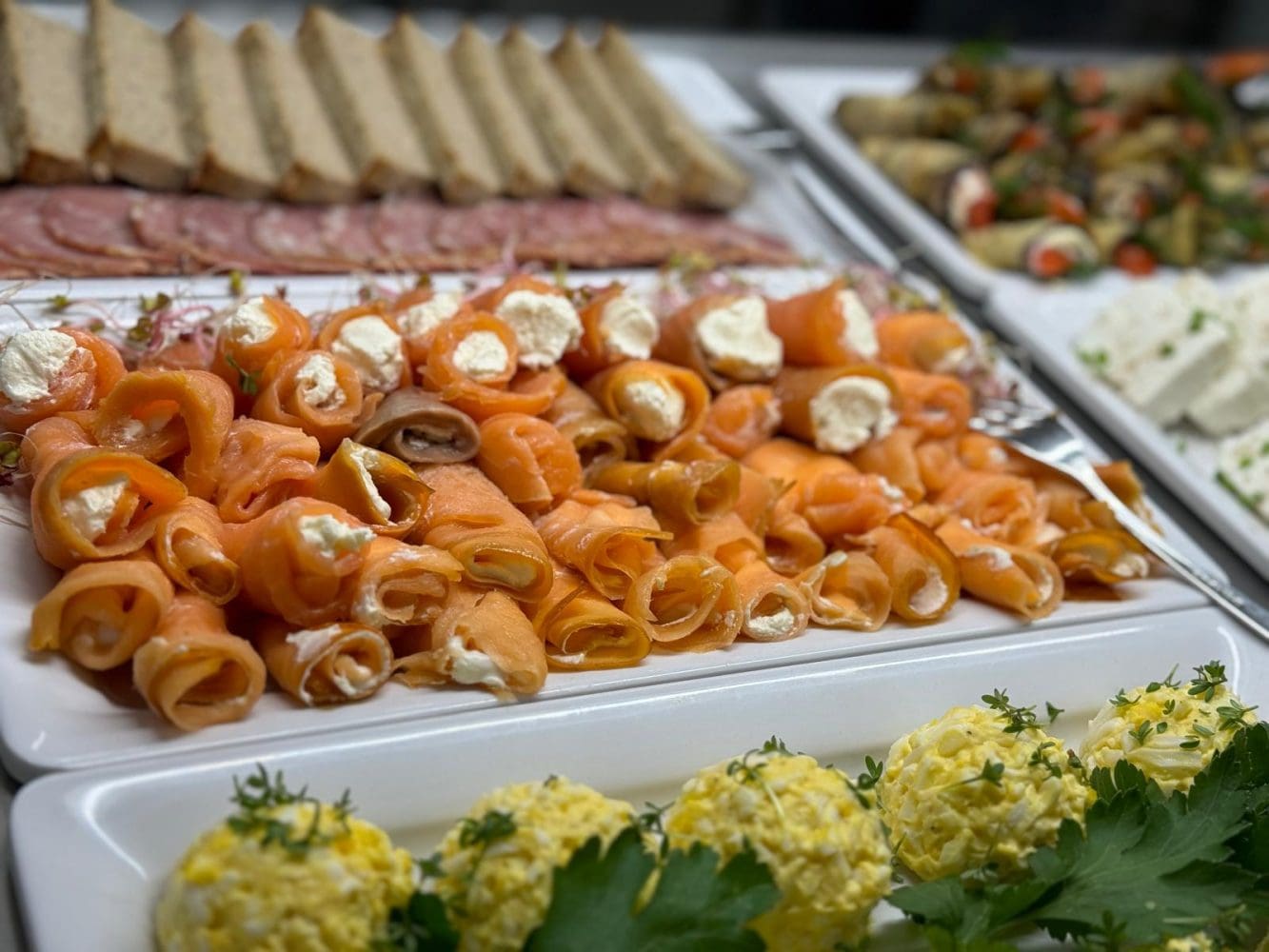 Wędzony łosoś w rolkach z serkiem, wędliny i pasta jajeczna na bufecie w restauracji Dobre Smaki