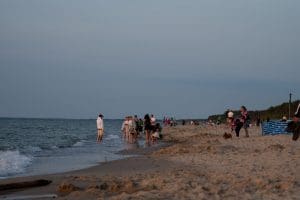 Plaża w Sarbinowie o zmierzchu z wałem wydmowym i drzewami po prawej