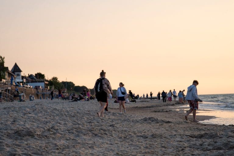 Spacerowicze na plaży w Sarbinowie w niskim słońcu późnego popołudnia