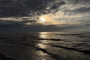 Zachmurzone niebo nad Bałtykiem i szara, wzburzona woda przy brzegu w Sarbinowie