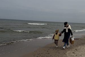 Rodzina idąca brzegiem Bałtyku w Sarbinowie w pochmurny dzień