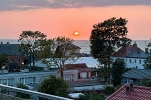 Zieleń i dachy Sarbinowa o zachodzie słońca, morze na horyzoncie