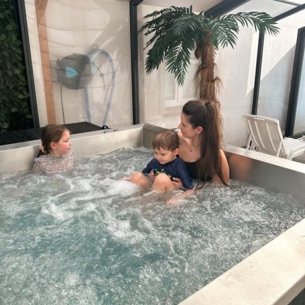 Mama z dwójką dzieci w jacuzzi pod szklanym zadaszeniem
