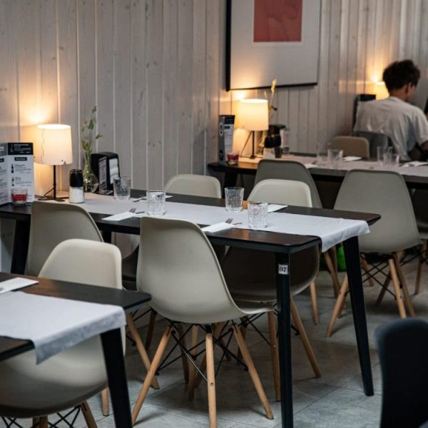 Sala restauracji z nakrytymi stolikami i zapalonymi lampkami