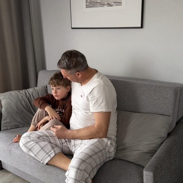 Tata z synem odpoczywają na sofie w apartamencie Wczasowej 8