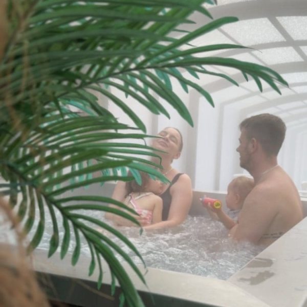 Rodzina z dwójką dzieci w jacuzzi pod szklanym dachem