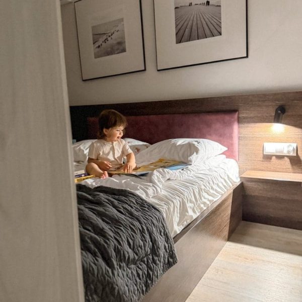 Dziewczynka czyta książeczkę na łóżku w sypialni apartamentu