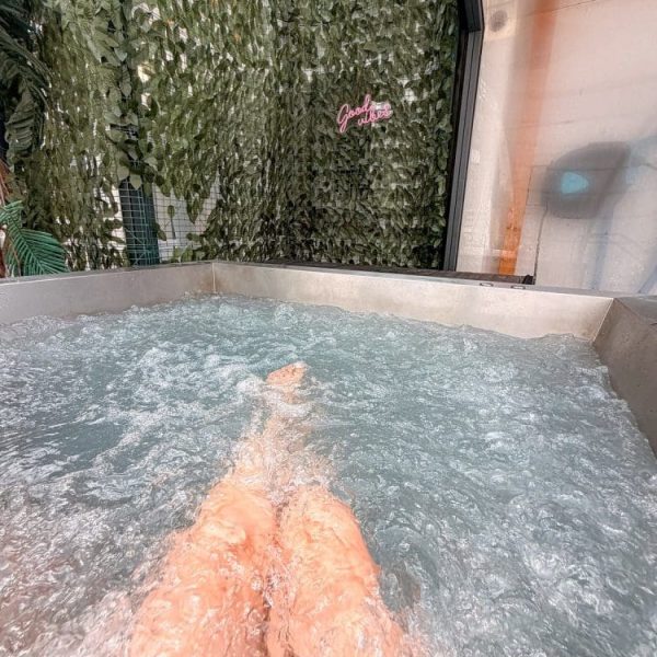 Relaks w bulgoczącym jacuzzi pod ścianą z zielonych liści